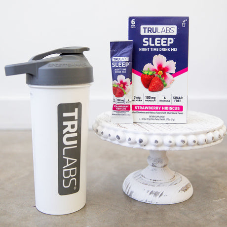TruLabs shaker bottle and Sleep Strawberry Hibiscus supplement packaging on a white surface